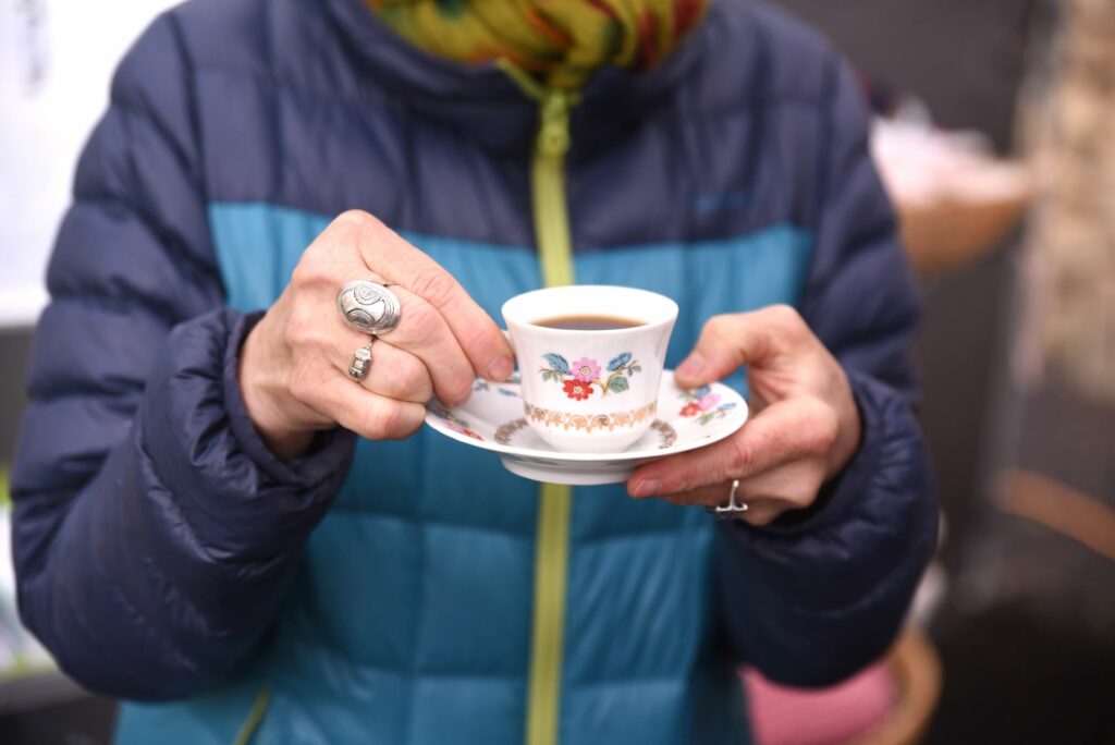 Les mains d'une dame âgée tenant une tasse de café vintage
